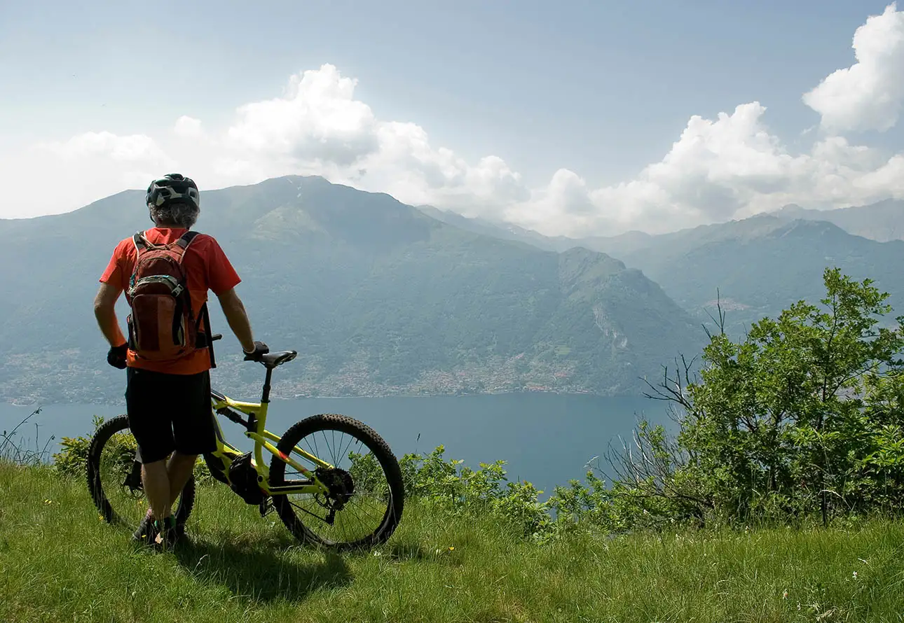 Biker enjoying Como Lake's scenic view amidst mountains