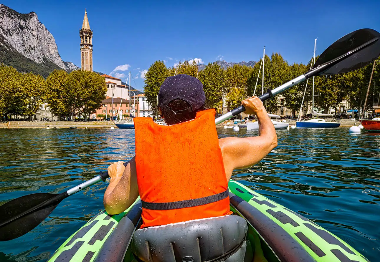 The kayaker, amidst their journey, is captured entering one of the charming towns surrounding Como Lake