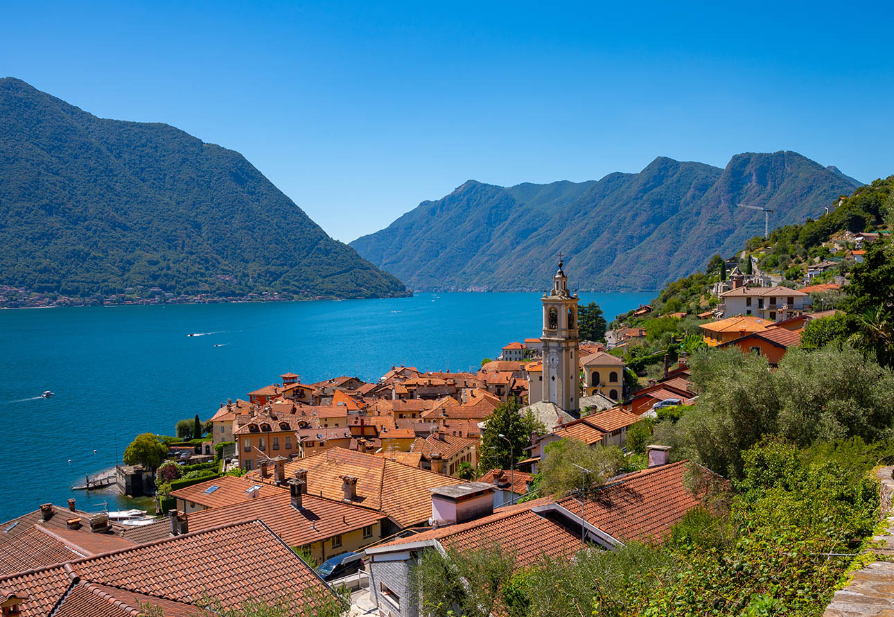 Captivating town by the lake with mountains, red rooftops, and greenway