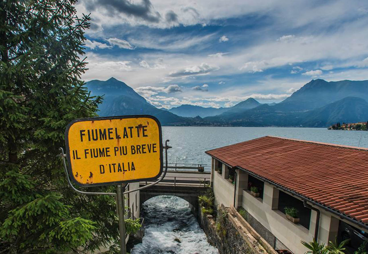 &#39;Signo italiano de filatelte cerca del río Fiumelatte con techo rojo a la vista