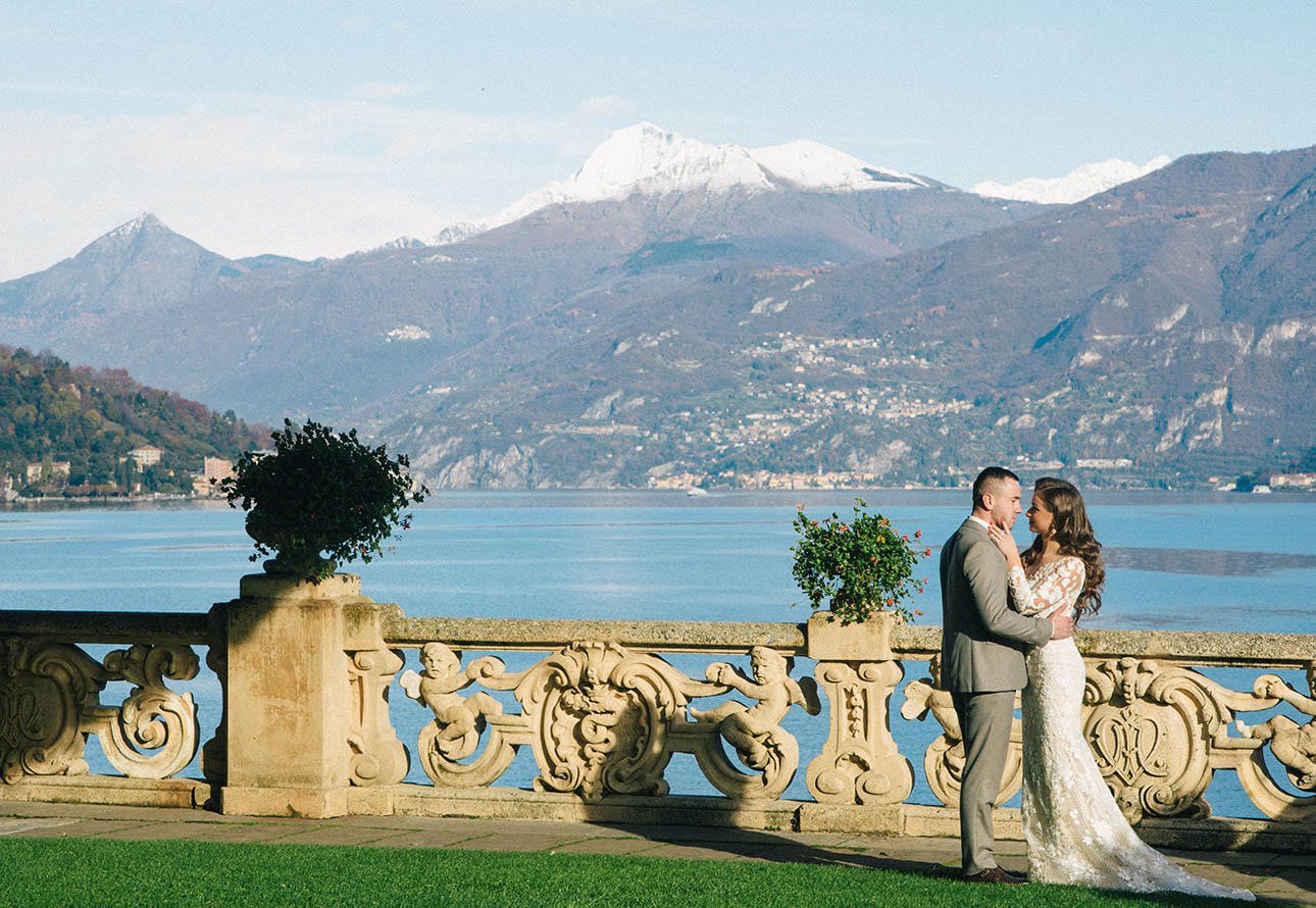 Braut und Bräutigam in der Villa del Balbianello küssen sich mit einem wunderschönen Blick auf den Comer See