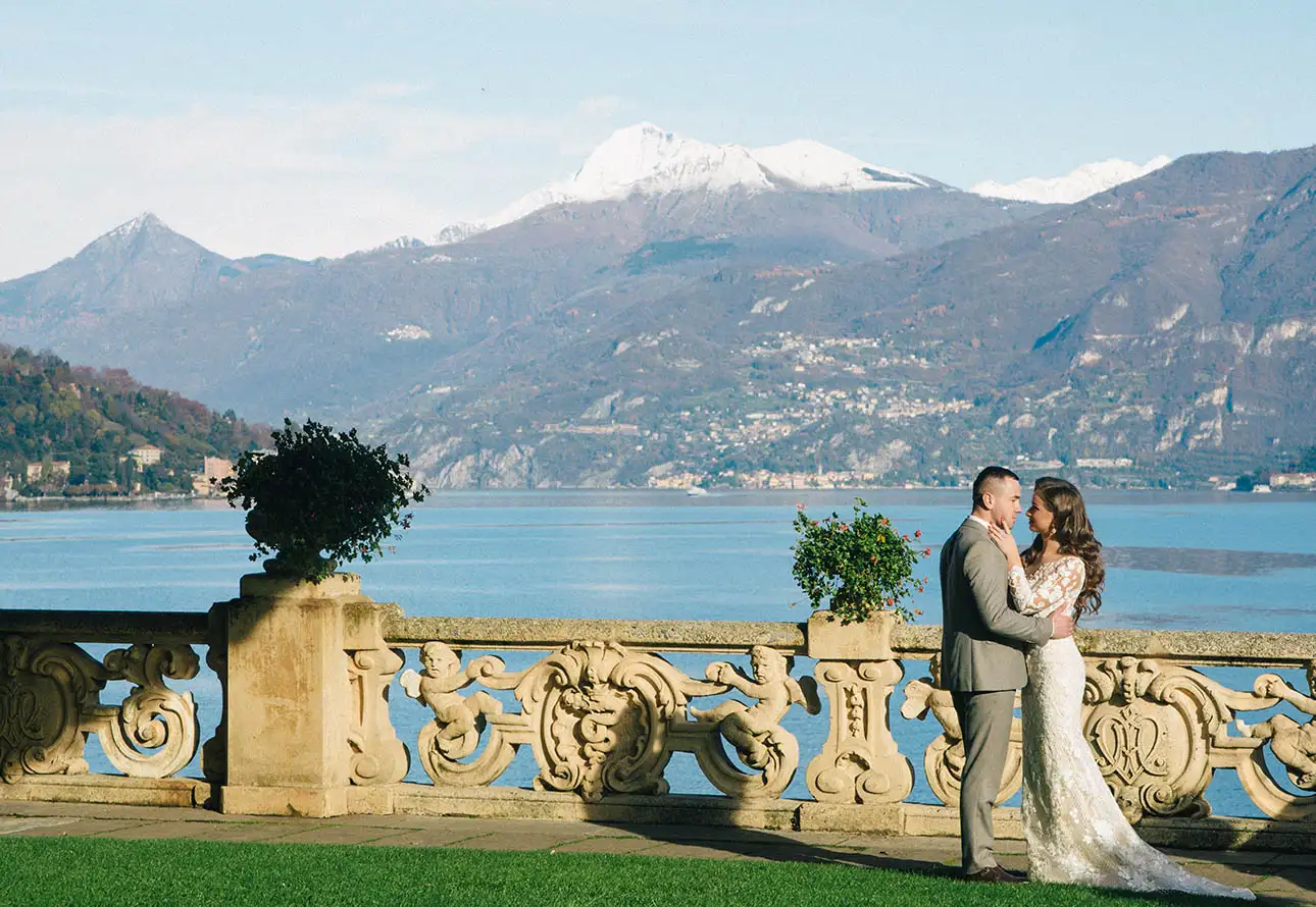 Bride and groom at Villa del Balbianello kissing with a beautiful Como Lake view